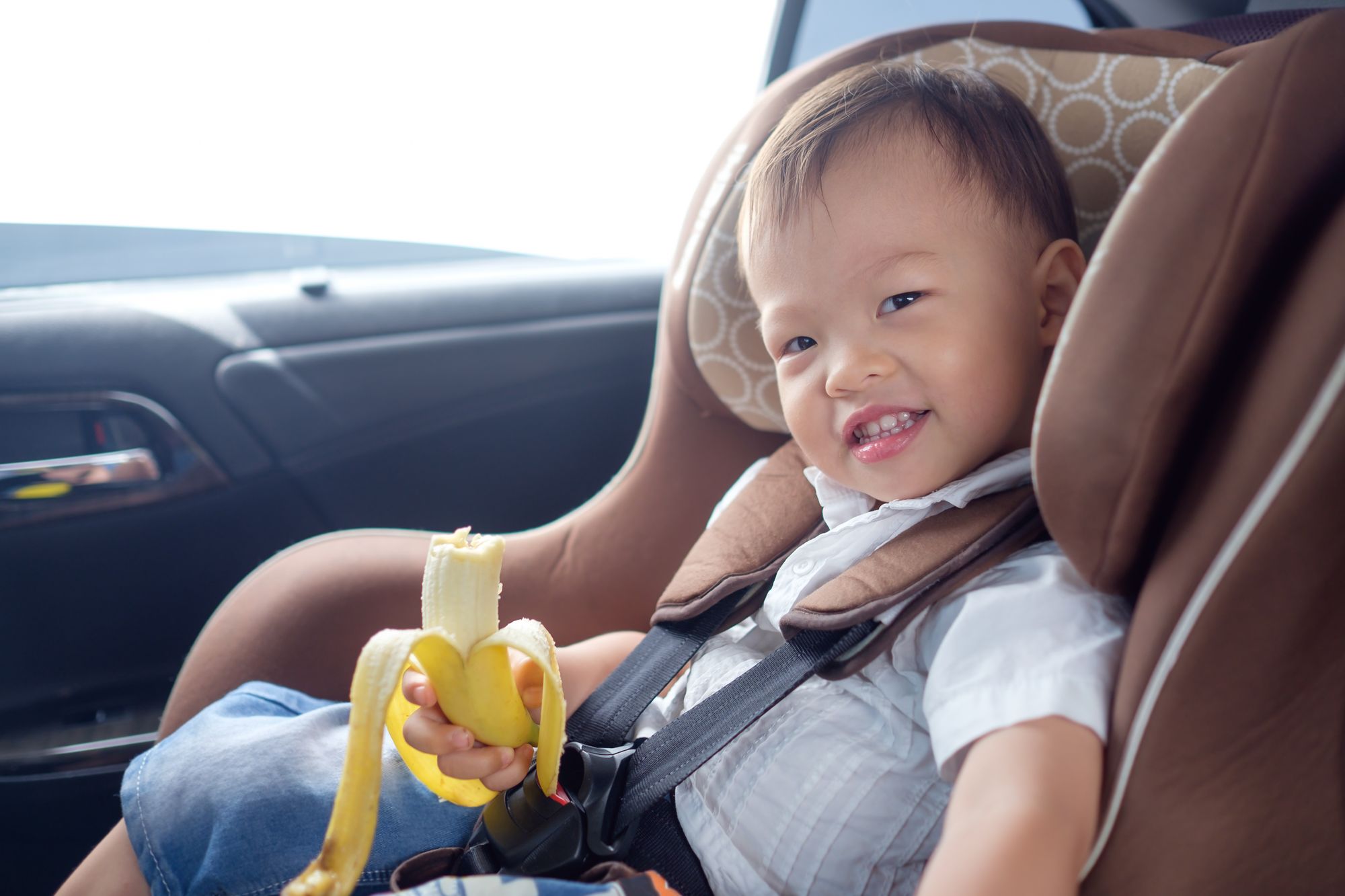 Kind im Auto mit Banane